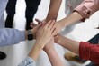 © New Africa - Unity concept. People holding hands together indoors, above view
