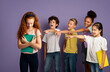 © Prostock-studio - Group of mean schoolchildren bullying their upset red-haired classmate on violet background