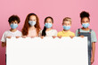 © Prostock-studio - Diverse kids in face masks holding empty poster on pink background, mockup for design