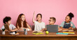 © Prostock-studio - Industrious Asian girl with her classmates studying at desk over pink background, empty space. Panorama