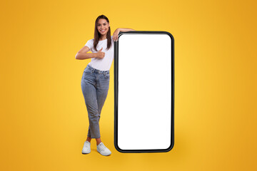 Aufkleber - Cool Mobile Offer. Happy casual lady leaning on huge cellphone with empty white screen, showing thumb up, recommending great new app or website for cell phone, offering space for your ad, mock up