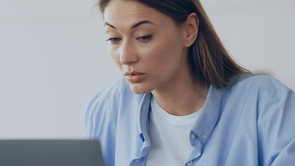 Poster - A woman looks astonished while reviewing content on her laptop in a contemporary office environment. The setting is bright and emphasizes her reaction to unexpected information.