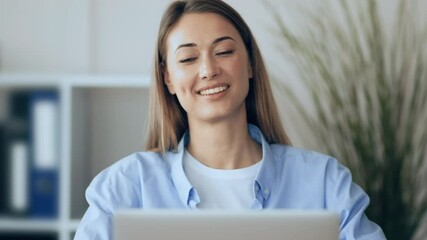Poster - A focused young woman engages with her laptop in a well-lit office, surrounded by plants and organizational tools, reflecting a productive work environment in the morning hours.