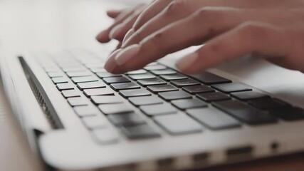 Poster - A person is focused on typing on a laptop keyboard, likely engaged in work or study. The cozy setting suggests a home environment, enhancing productivity and creativity.