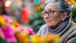 © atipong - A Thoughtful Senior Amidst Vibrant Blossoms in a Tranquil Setting