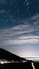 Wall Mural - night sky with stars and spain city bellow, time lapse view