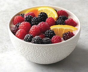 Canvas Print - Berries and orange slices in a bowl, light grey counter background for a fresh breakfast or dessert