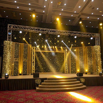 A luxurious golden stage background adorned with sparkling glitters and illuminated by vibrant spotlights.