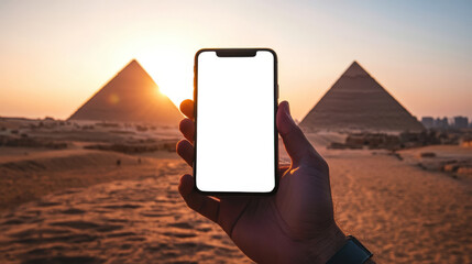 Pyramids of Giza in Egypt at sunset. A phone mockup for the presentation of a mobile application on tourism and travel. A man is holding a phone with an empty screen in his hand