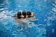 © AmpYang Images - Three Asian teenage girls playing and embracing each other inside a swimming pool