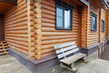 Wall Mural - A wooden bench is outside of a log cabin