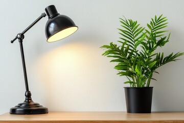 Poster - Elegant black desk lamp illuminating a cozy workspace with a vibrant green potted plant creating a serene and inviting atmosphere for study or work