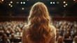 © Almahyra - Woman speaker addressing large audience in auditorium