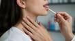 © Sasa Visual - A patient receives a throat examination in a medical clinic, focused on health assessment
