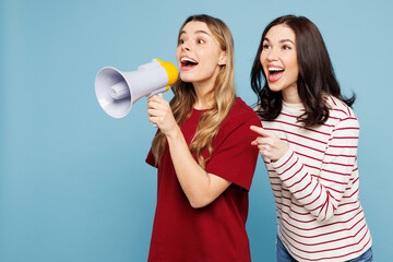 Wall Mural - Young happy couple two friends women wearing red casual clothes together hold megaphone scream announces discounts sale Hurry up isolated on pastel plain light blue cyan background. Lifestyle concept.