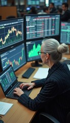 Leinwandbilder - Elderly Caucasian woman analyzes financial data at multiple screens in a busy trading room during the day