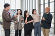 © PhugunStock - Asian business men and women standing happily talking After brainstorming and talking about analytics, innovation, and collaboration. online business Modern sales techniques and strategic planning