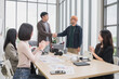 © PhugunStock - Happy Asian business men holding hands, brainstorming, talking about analysis, innovation and collaboration. Online business, sales techniques, strategic planning