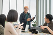 © PhugunStock - Asian male businessman explaining Happily holding a tablet in a meeting, brainstorming and talking about analysis, innovation, collaboration. online business Sales techniques and strategic planning