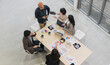 © PhugunStock - Top view of business people, Asian man and woman looking at camera, hands raised, happy, talking about analysis, innovation and collaboration. Online business, sales techniques, strategic planning
