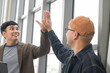© PhugunStock - Asian male businessman Tag a friend's hand happy smile Holding a tablet, talking about analytics, innovation, and collaboration. Online business, sales techniques, strategic planning