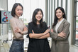 © PhugunStock - Asian businesswoman stands happily looking at the camera, arms crossed. After talking about analytics, innovation and collaboration. Online business, sales techniques, strategic planning