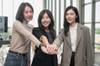 © PhugunStock - Asian business woman Join forces with friends, look into the camera, brainstorm and talk about analysis, innovation, and collaboration. Online business, sales techniques, modern strategic planning