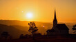 © Tasha - Serene church silhouette against sunset hills, peaceful tranquility