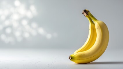 Poster - fresh yellow bananas arranged on a smooth surface with soft lighting creating a calm atmosphere