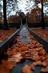 Poster - Autumn leaves fill playground slide; nature background. For seasonal display