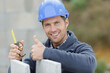 © auremar - male builder holding a tape measure in hands