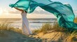 © Alexandr - Woman in a flowing white dress waving a turquoise scarf on the beach