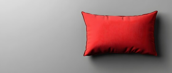 Poster - Minimalist Studio Shot of a Vibrant Red Pillow Against a Soft Gray Background with Copy Space