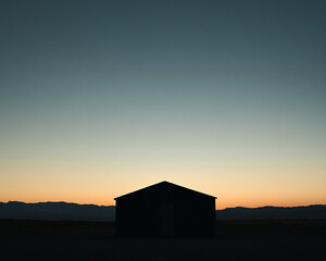 Poster - A small wooden cabin stands alone at sunset with mountains in the background, symbolizing isolation, solitude, and peacefulness in nature with a serene twilight sky.