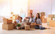 © New Africa - Happy family in sunlit room with cardboard boxes on moving day