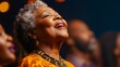 © Anastasiia S - An African elderly woman with closed eyes in traditional clothing sings in the choir among other performers. Copy space. Carefree retirement concept, hobby, music, religion
