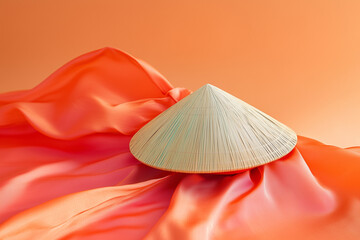 A Vietnamese conical hat (nón lá) resting on a silk ao dai dress, isolated on a solid color background.