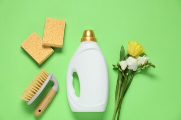 Wall Mural - Spring cleaning. Detergent, supplies and flowers on green background, flat lay