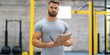 © Andrii Zastrozhnov - A man with a clipboard stands in a gym. He is wearing a gray shirt and has a beard