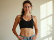 © Leonardo - Hermosa mujer joven con un elegante sujetador deportivo negro y jeans holgados de color claro