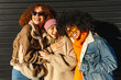 © Alberto - Three diverse female friends are hugging and laughing, enjoying a sunny day together