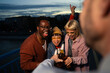 © liderina - Group of Multi-Ethnicity people having fun outdoor in the night. Celebrate.