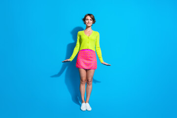 Wall Mural - Full length body photo of candid charming lady in green cardigan and pink mini skirt posing glad isolated on aquamarine color background