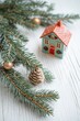 © vefimov - Green pine with red ornaments and toy house decorated for Christmas.