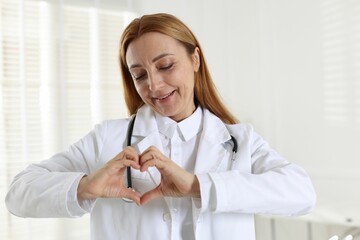 Wall Mural - Cardiologist making heart with hands in hospital