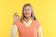 © New Africa - Senior woman showing okay gesture on yellow background