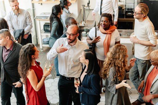 diverse group of people at social event, mingling and chatting. diverse crowd enjoy drinks and conve