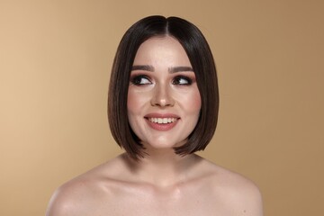 Wall Mural - Portrait of beautiful young happy woman with gorgeous straight hair on beige background