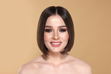 Wall Mural - Portrait of beautiful young happy woman with gorgeous straight hair on beige background