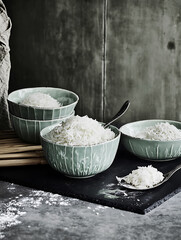 Sticker - Here's a description suitable for a photo title: Turquoise bowls filled with white flakes arranged on a dark surface with spoons against a textured backdrop.